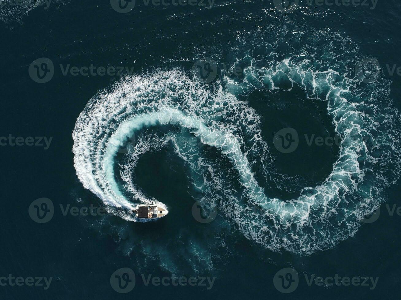 Aerial top view of a white pleasure boat on a summer day. Powerboat turn loop eight on the sea making infinity future concept. photo