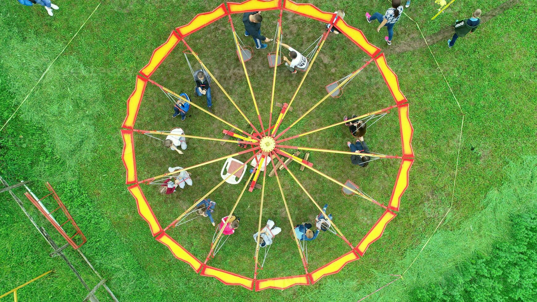 Carnival Merry Go Round aerial top view. Drone tracking rotation shoot. photo