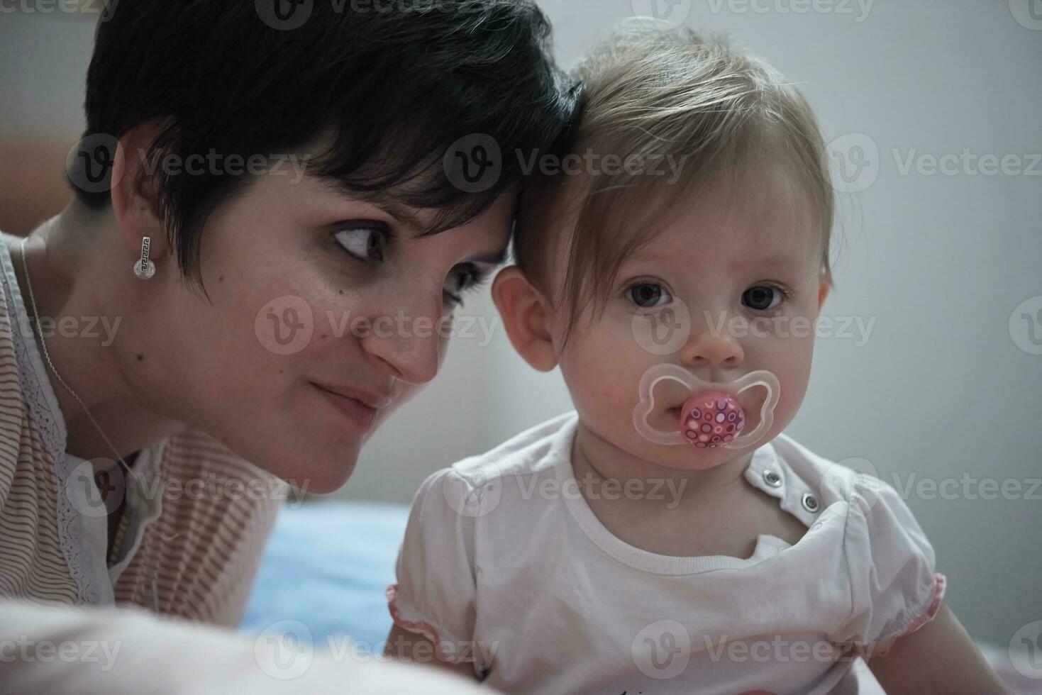 la madre está jugando con el bebé en casa foto