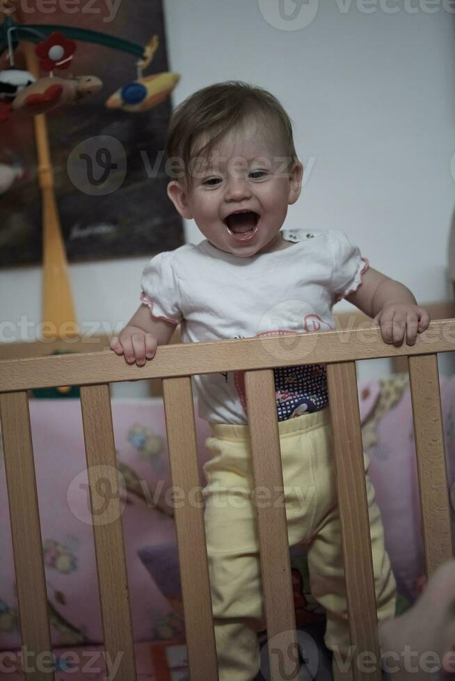 cute  little one year old baby and making first steps in bed photo