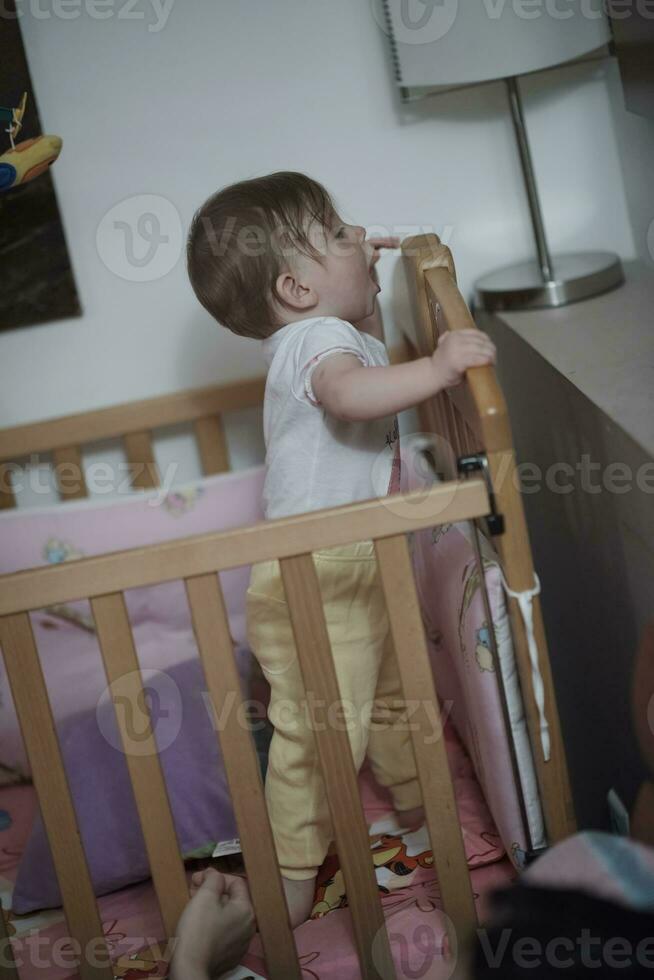 lindo bebé de un año y dando los primeros pasos en la cama foto