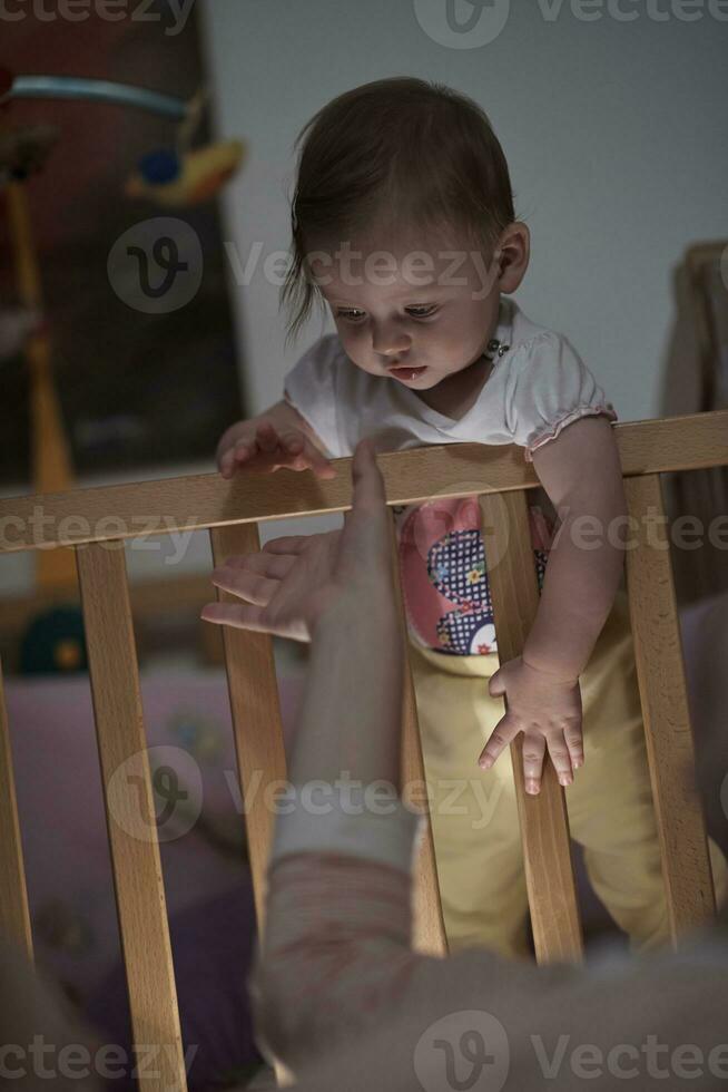 cute  little one year old baby and making first steps in bed photo