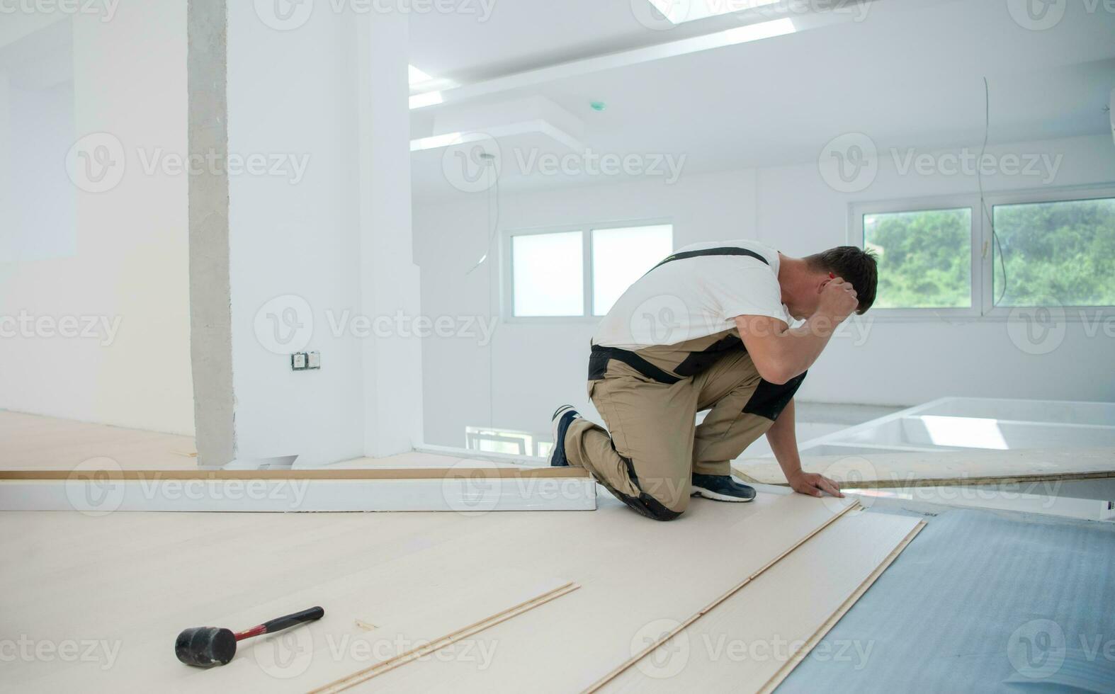 Worker Installing New Laminated Wooden Floor photo