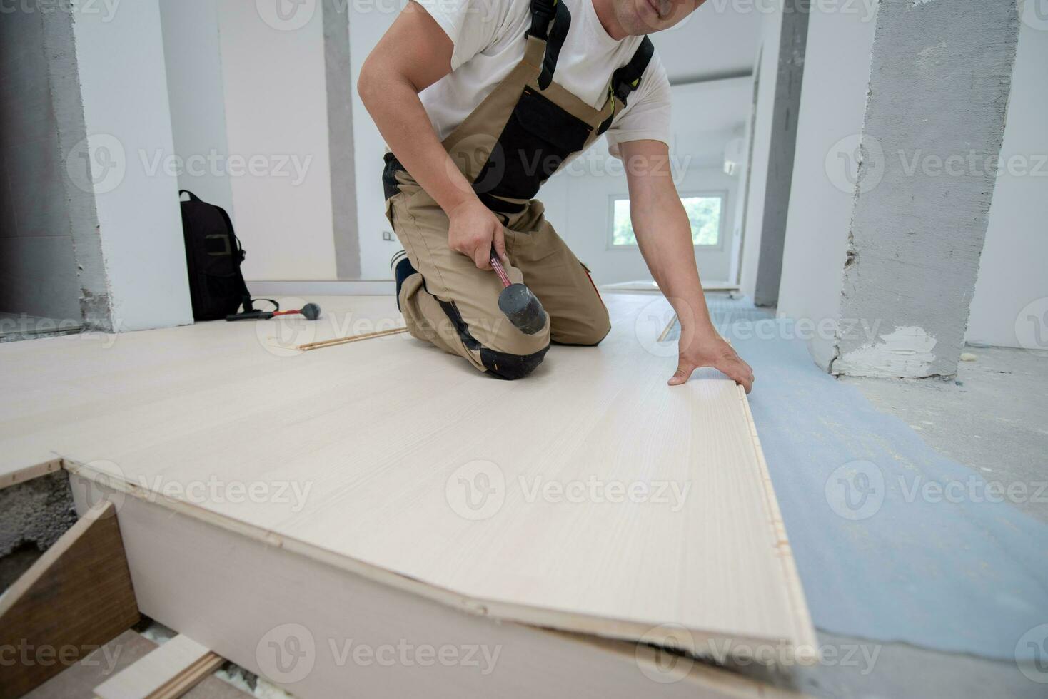 Professional Worker Installing New Laminated Wooden Floor photo