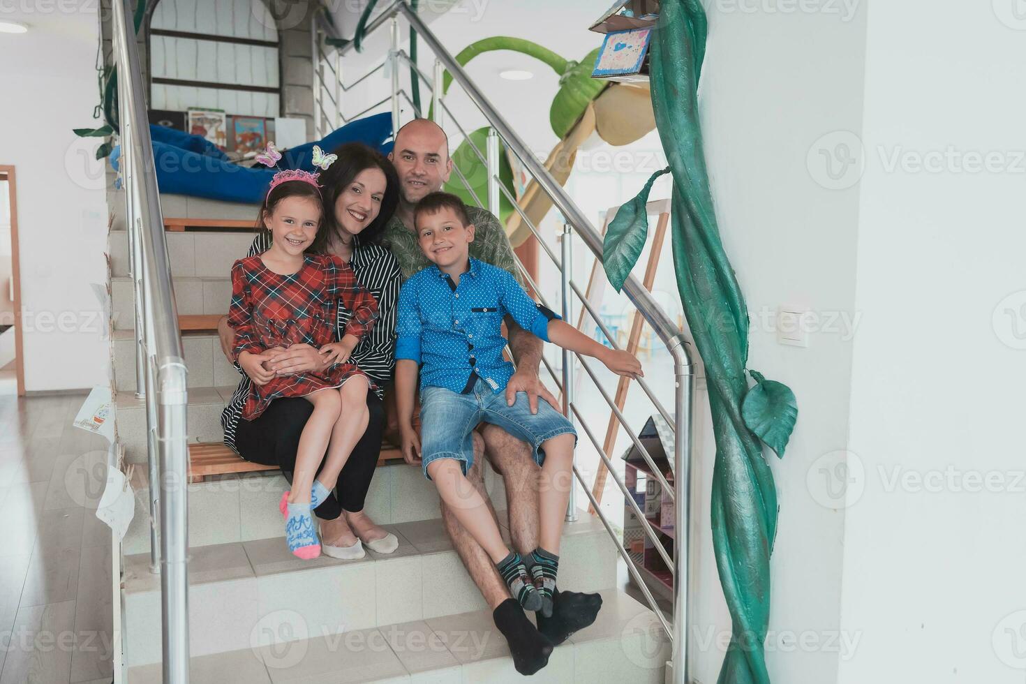 Portrait of a happy family. Photo of parents with children in a modern preschool classroom. Selective focus