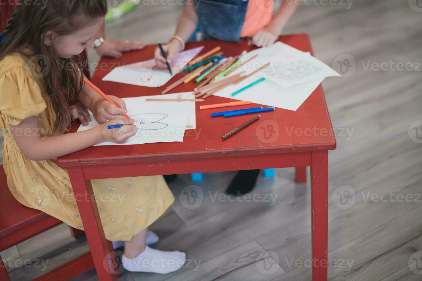 creativo niños sentado en un preescolar institución, dibujar y tener divertido mientras ellos obtener un educación foto