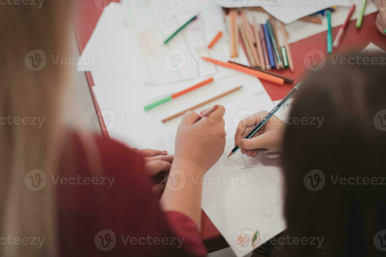 Creative kids sitting in a preschool institution, draw and have fun while they get an education photo