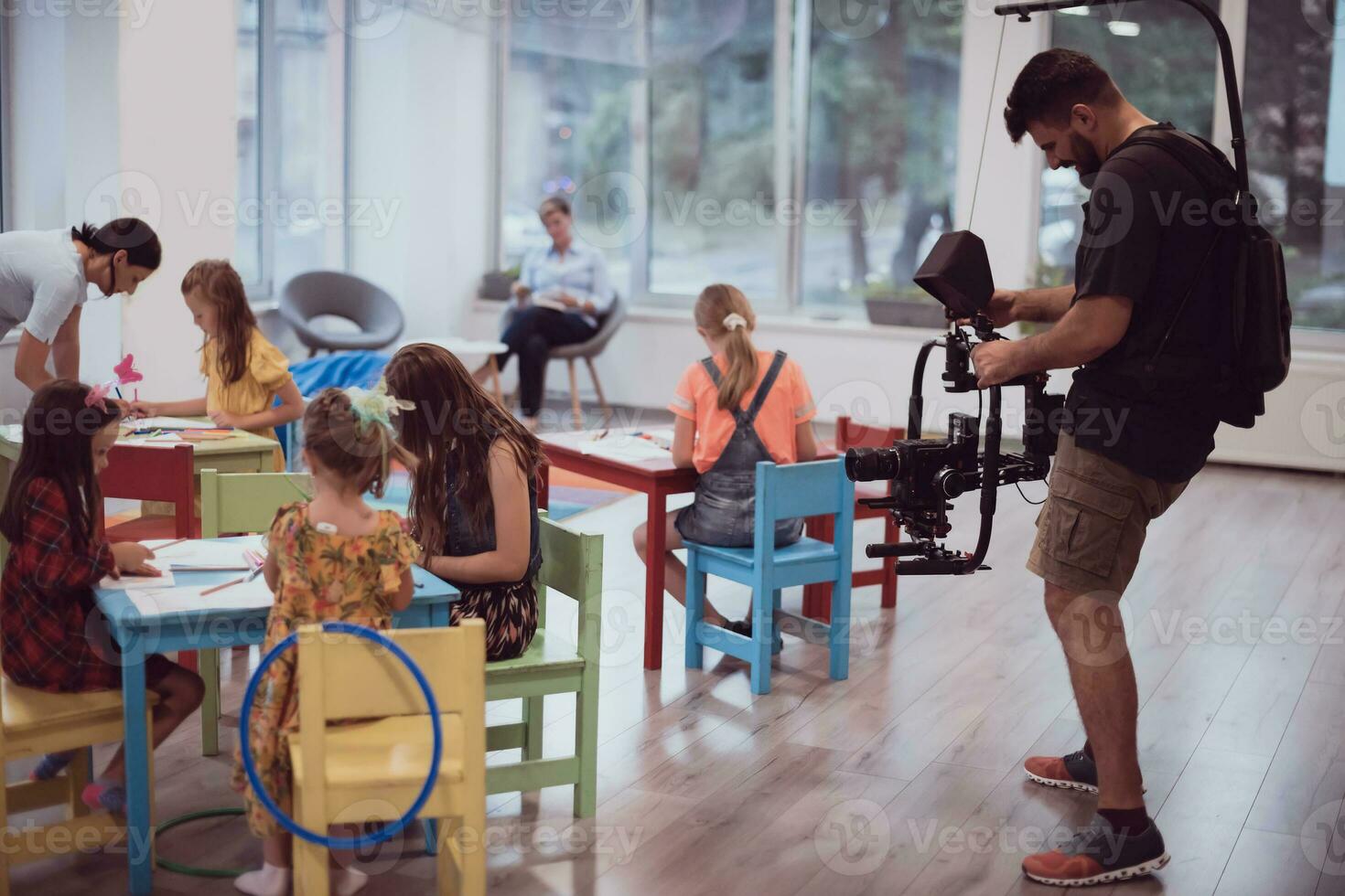 un camarógrafo con un profesional cámara registros para niños socializando en un preescolar institución foto