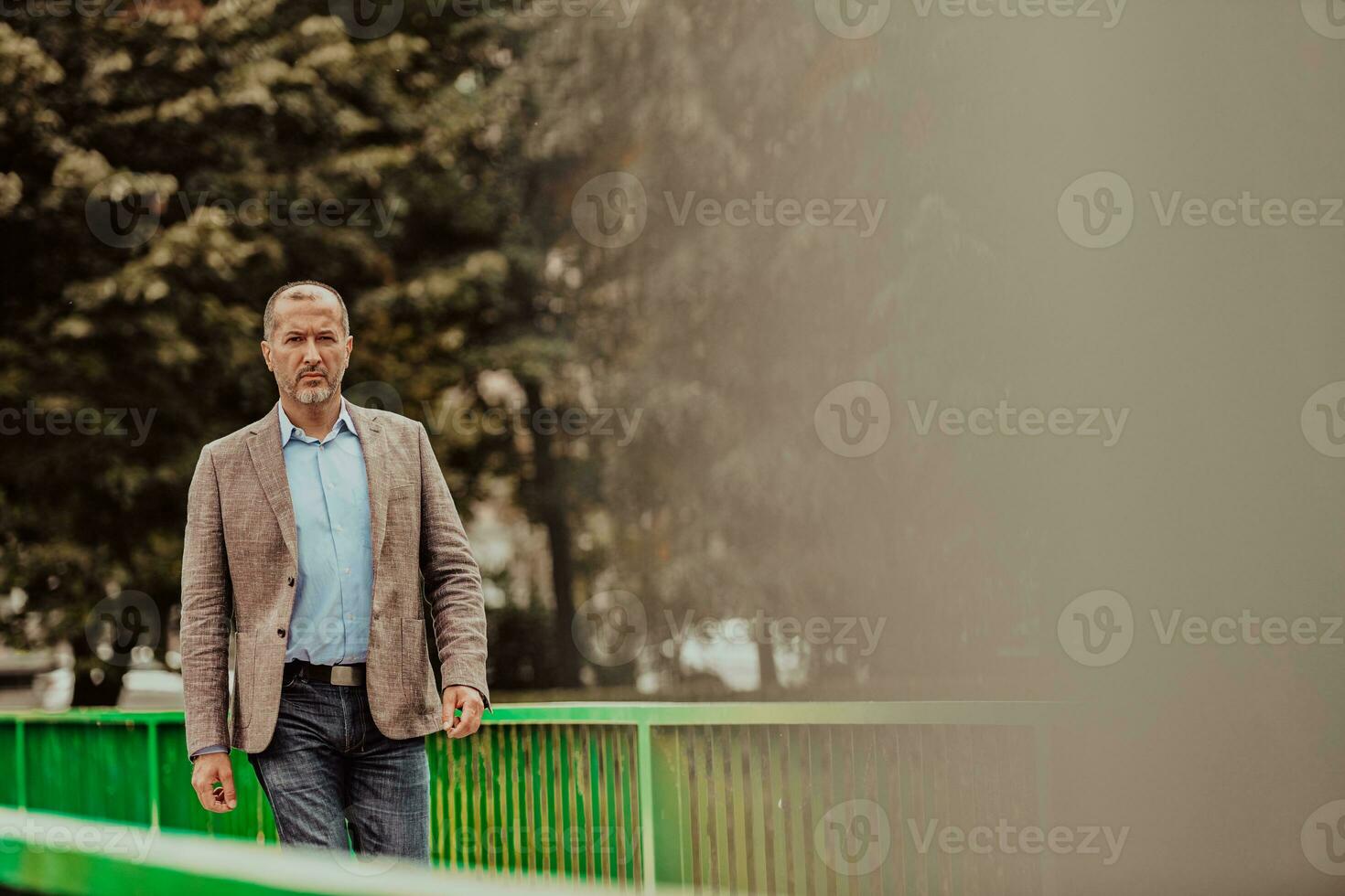 Focused businessman in a suit walking in the park photo