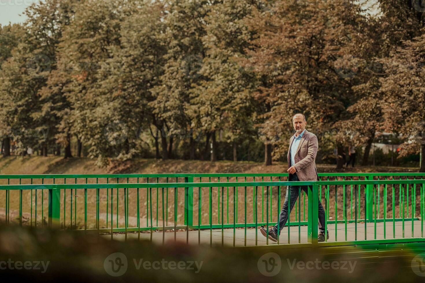 focused businessman in suit walking in urban environment. photo