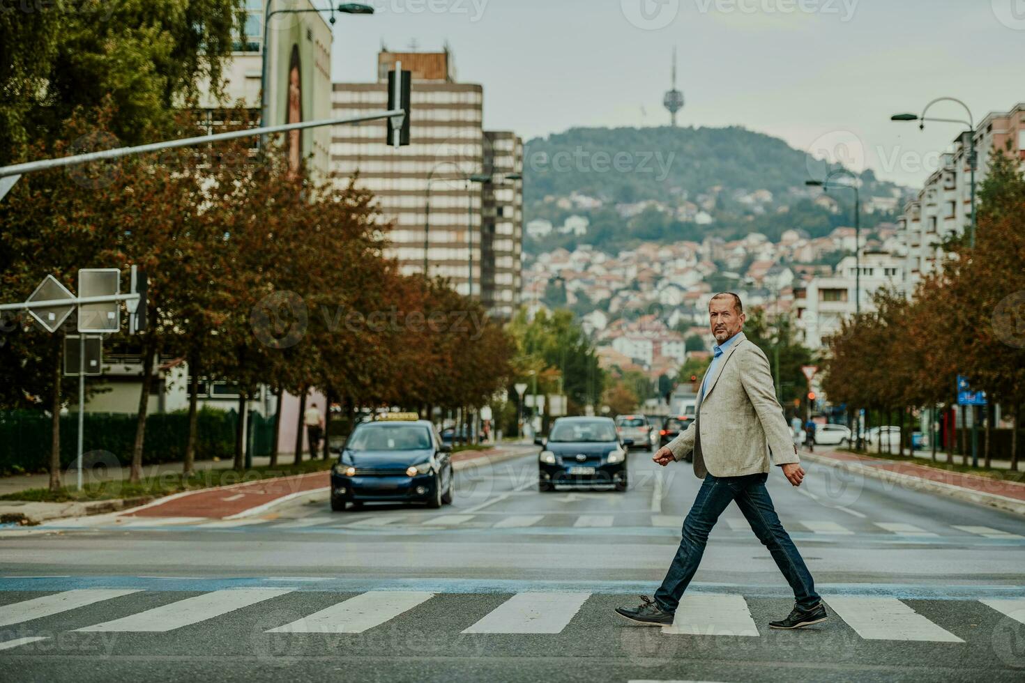 focused businessman in suit walking in urban environment. photo