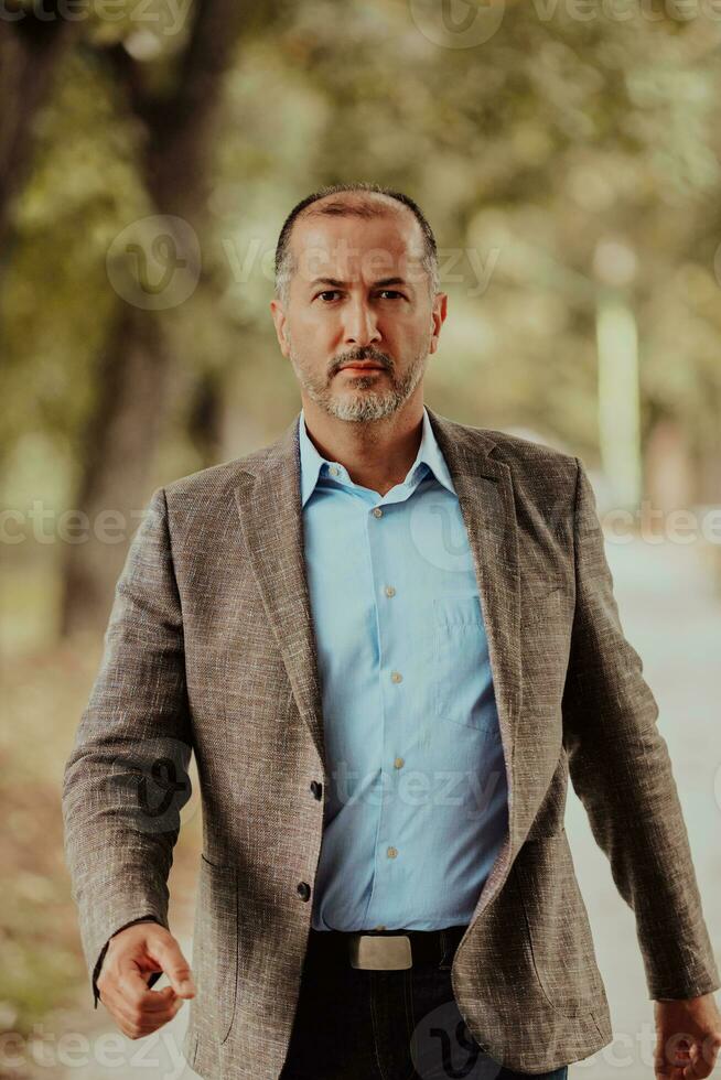 Focused businessman in a suit walking in the park photo