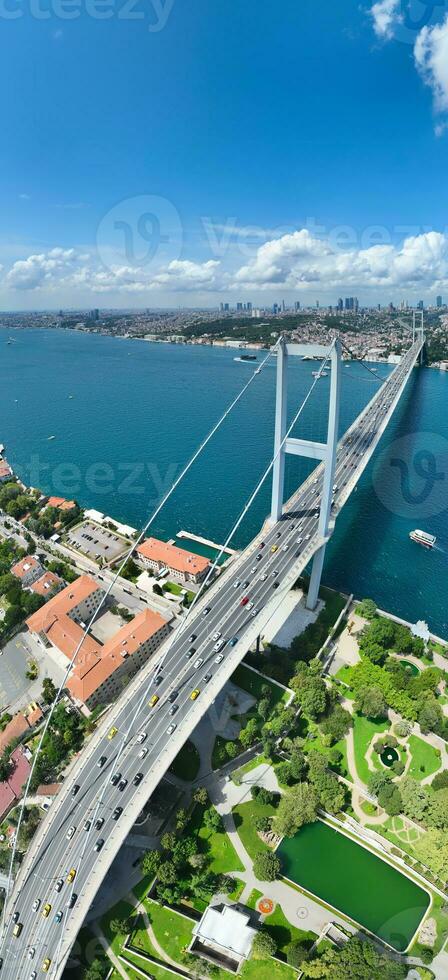 Istanbul Bosphorus Bridge and City Skyline in Background with Turkish Flag at Beautiful Sunset, Aerial slide orbiting and tracking shot photo