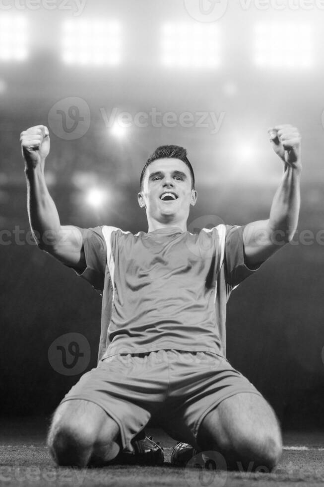 soccer player in front of big modern stadium with flares and lights photo