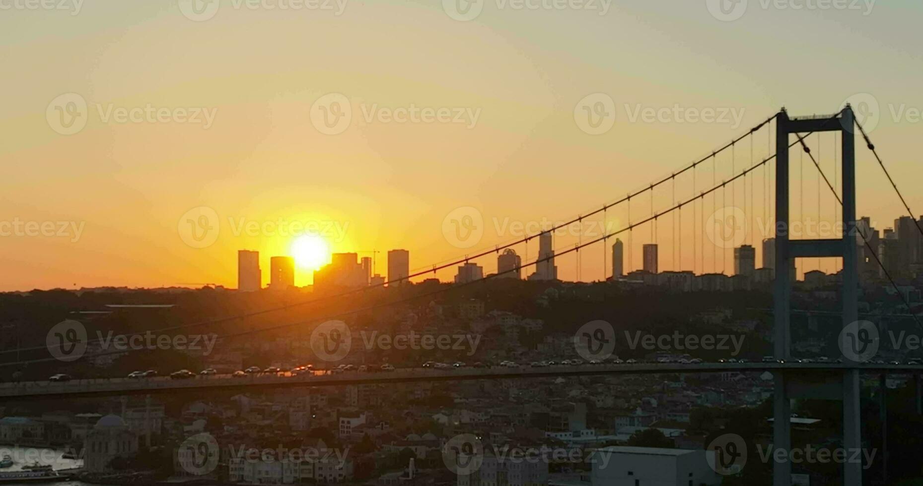 Istanbul Bosphorus Bridge and City Skyline in Background with Turkish Flag at Beautiful Sunset, Aerial slide orbiting and tracking shot photo