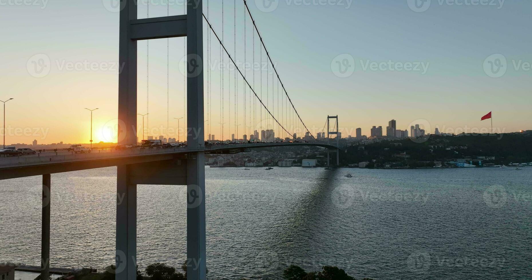 Estanbul bósforo puente y ciudad horizonte en antecedentes con turco bandera a hermosa atardecer, aéreo diapositiva orbital y rastreo Disparo foto