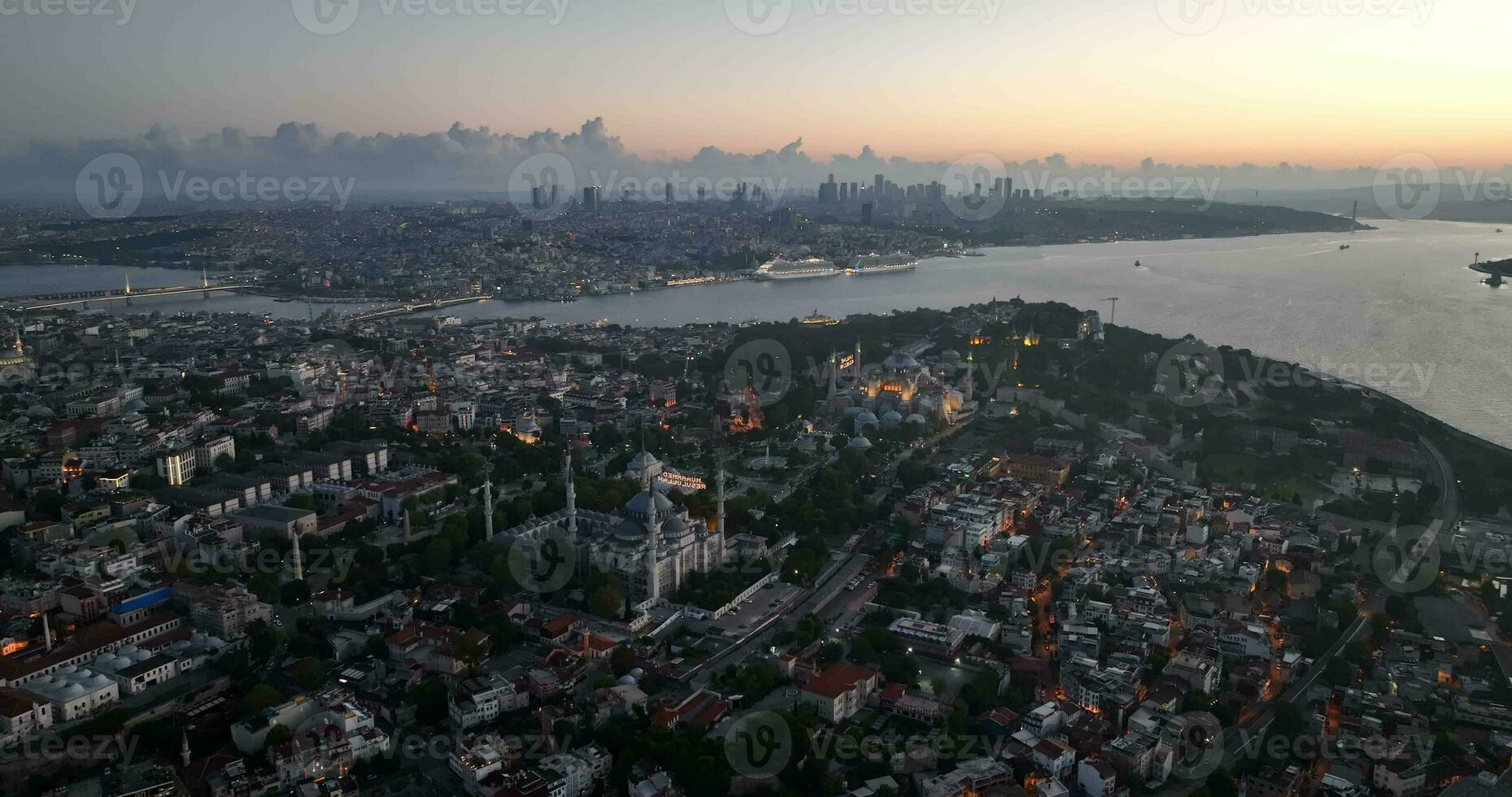 Istanbul, Turkey. Sultanahmet with the Blue Mosque and the Hagia Sophia with a Golden Horn on the background at sunrise. Cinematic Aerial view. photo