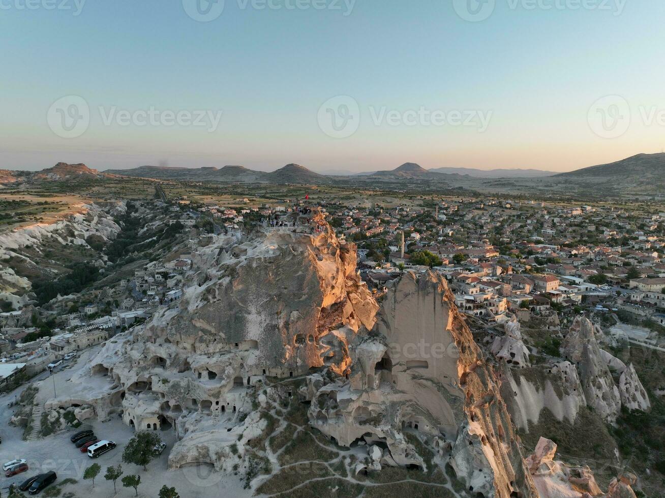 Aerial view of natural rock formations in the sunset, valley with cave houses in Cappadocia, Turkey. Natural landscape city lights at the night. photo