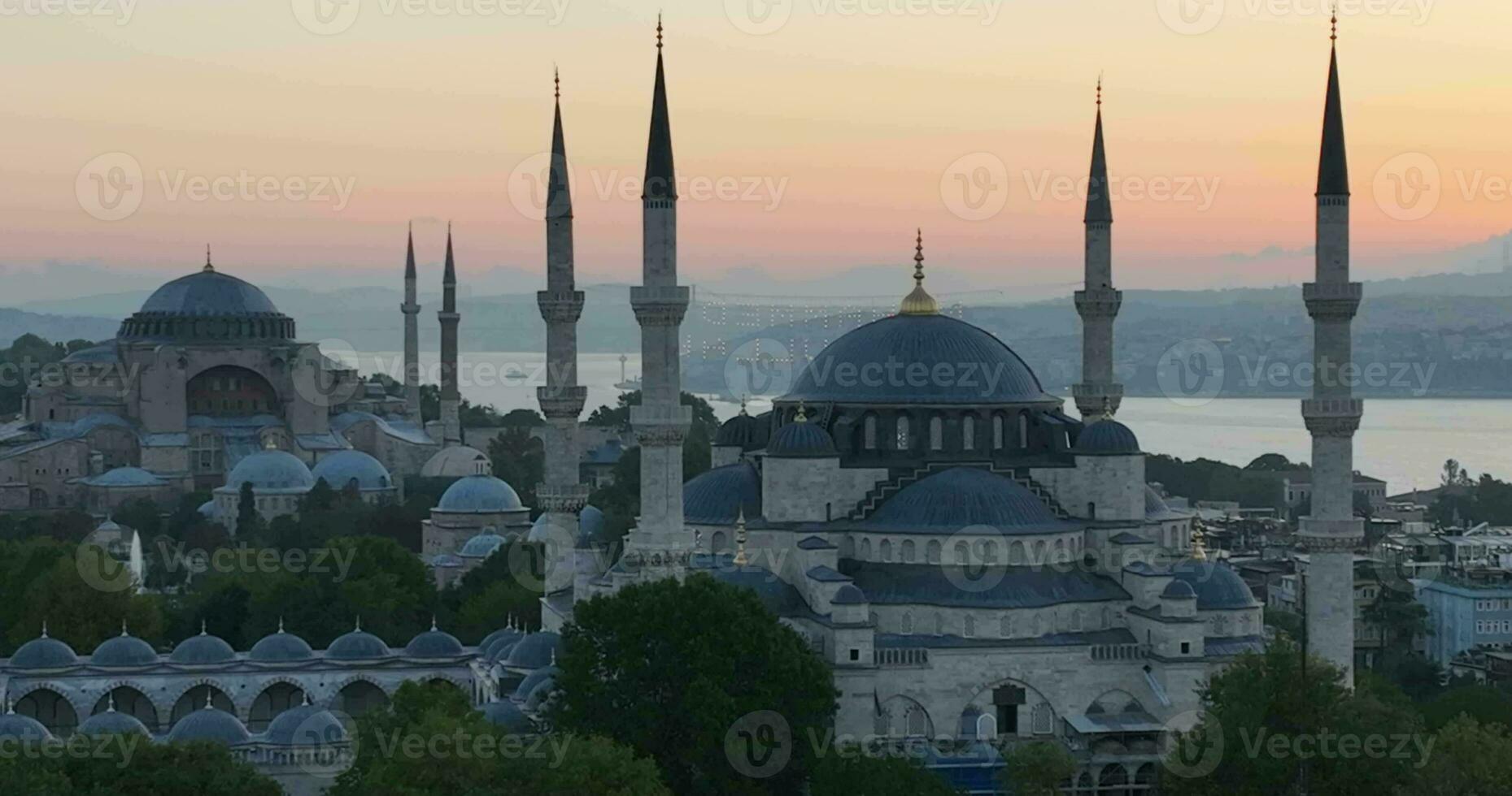 Istanbul, Turkey. Sultanahmet with the Blue Mosque and the Hagia Sophia with a Golden Horn on the background at sunrise. Cinematic Aerial view. photo