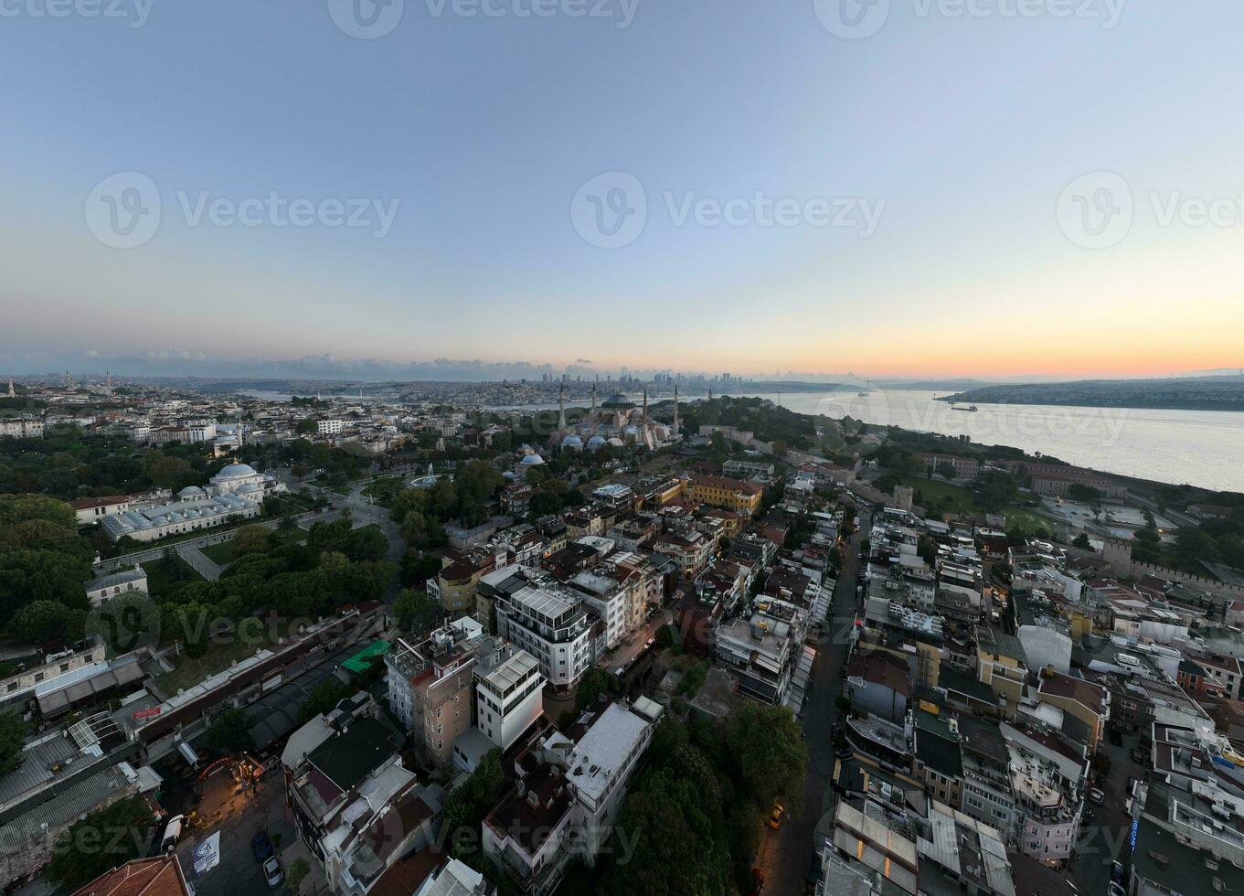 Istanbul, Turkey. Sultanahmet with the Blue Mosque and the Hagia Sophia with a Golden Horn on the background at sunrise. Cinematic Aerial view. photo