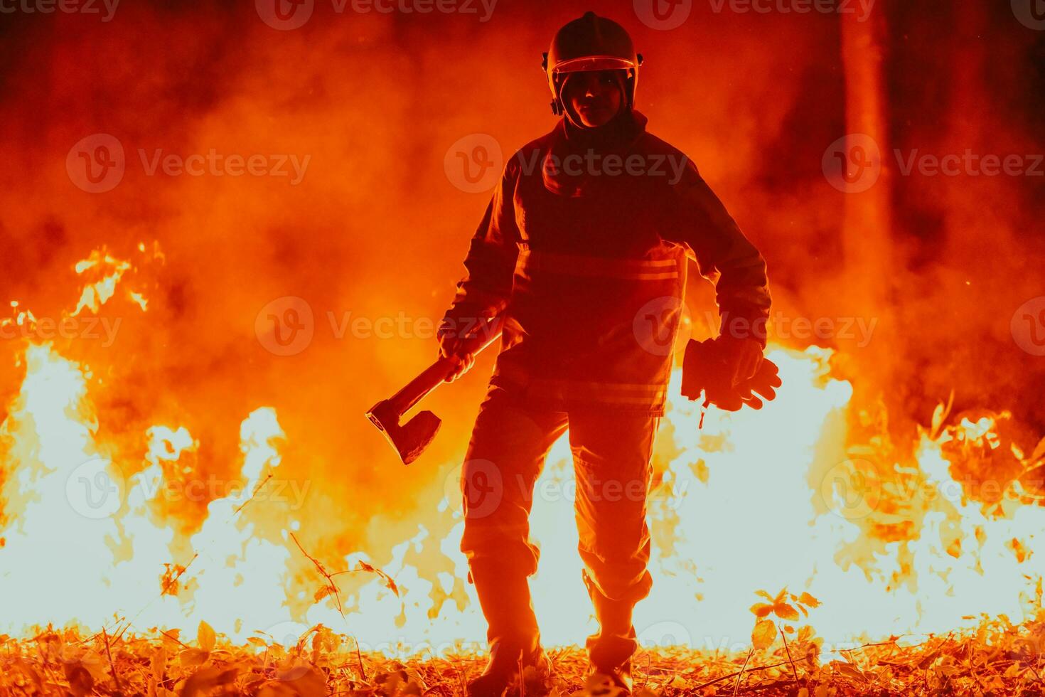 Firefighter at job. Firefighter in dangerous forest areas surrounded by strong fire. Concept of the work of the fire service photo