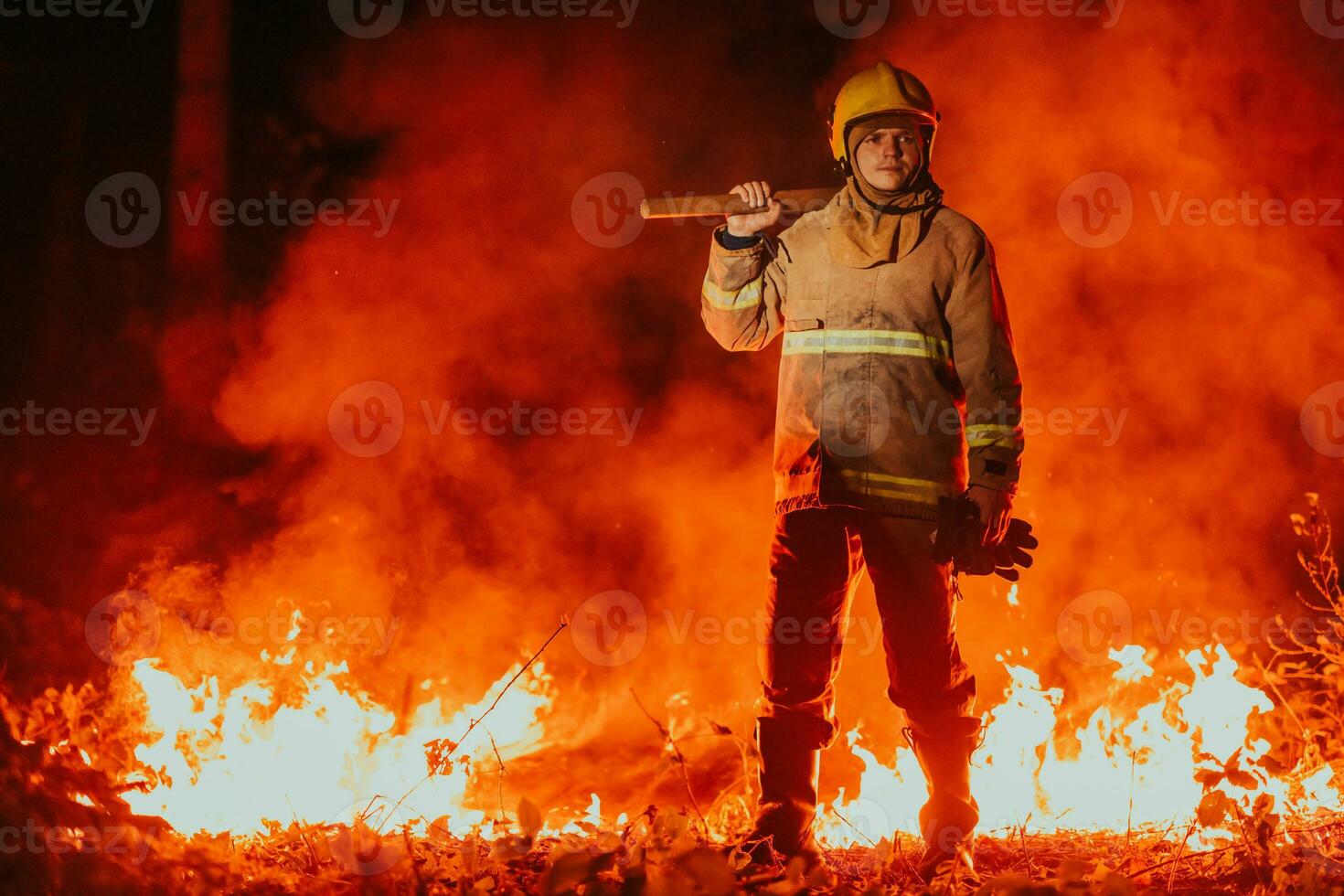 Firefighter at job. Firefighter in dangerous forest areas surrounded by strong fire. Concept of the work of the fire service photo