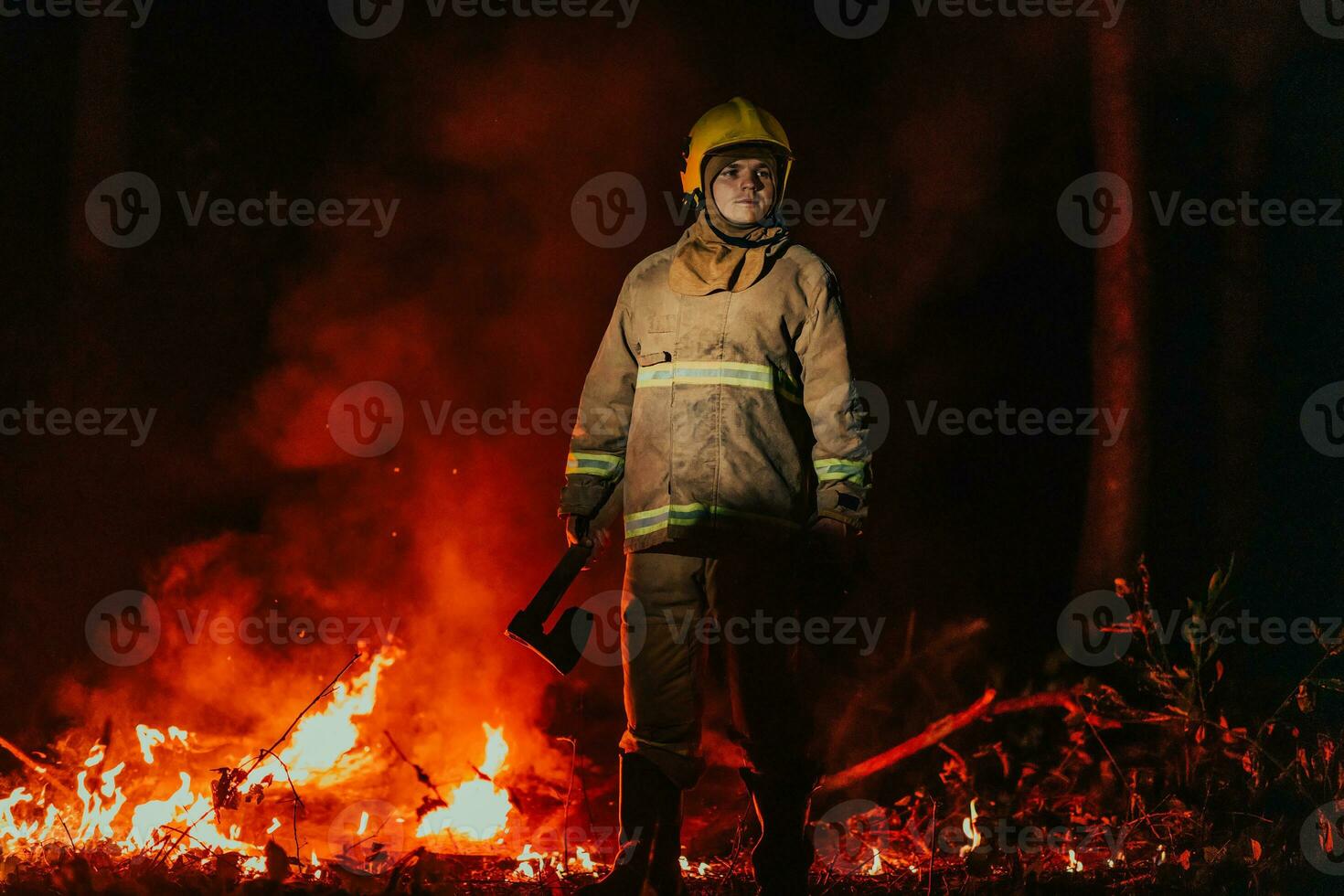 Firefighter at job. Firefighter in dangerous forest areas surrounded by strong fire. Concept of the work of the fire service photo