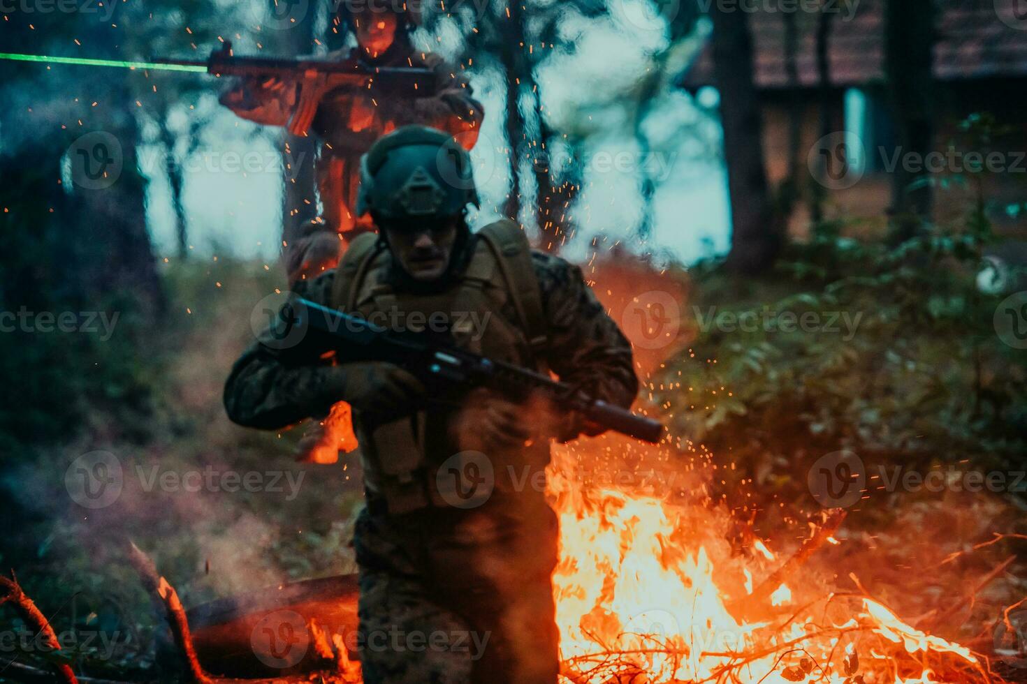 Soldier in Action at Night in the Forest Area. Night Time Military Mission jumping over fire photo