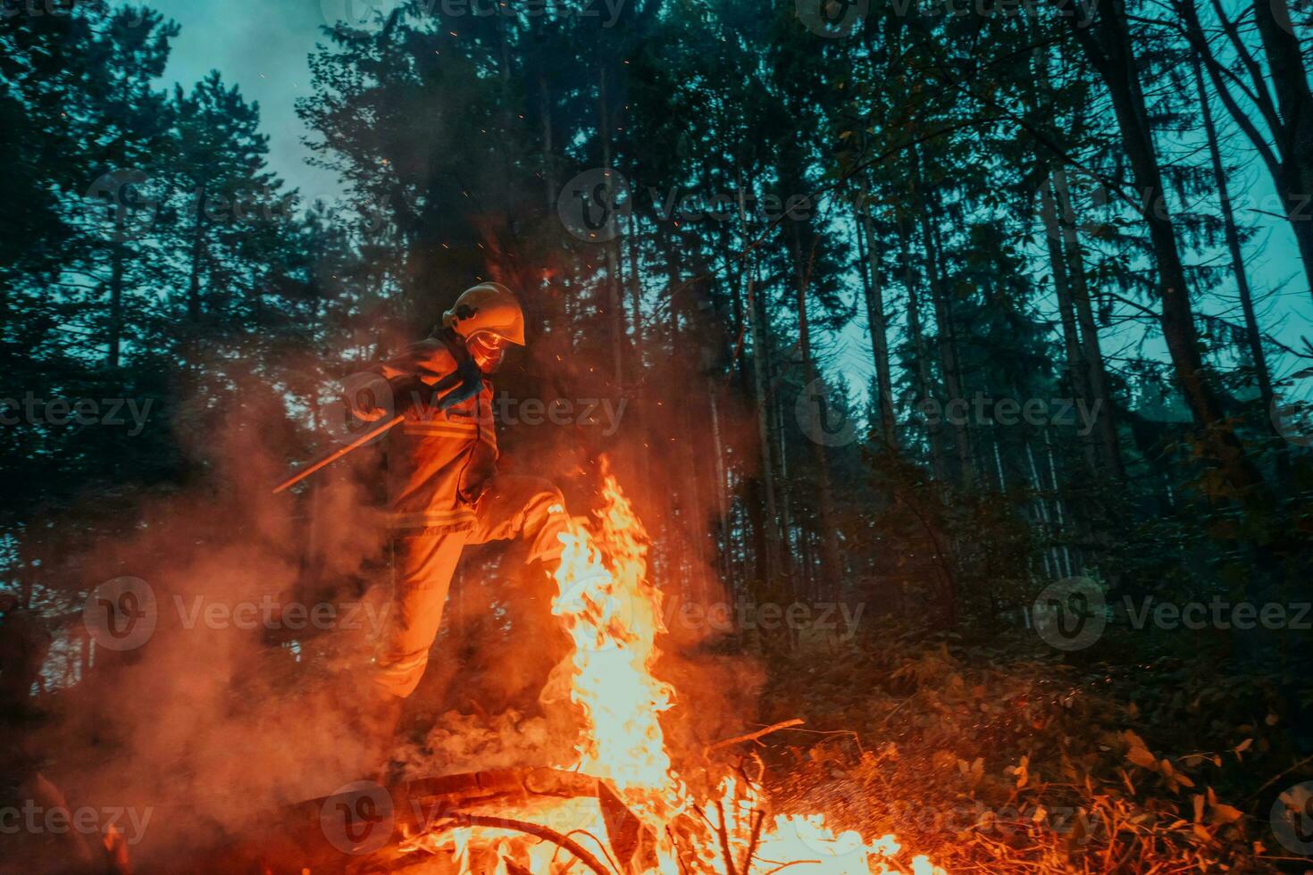 firefighter hero in action danger jumping over fire flame to rescue and save photo
