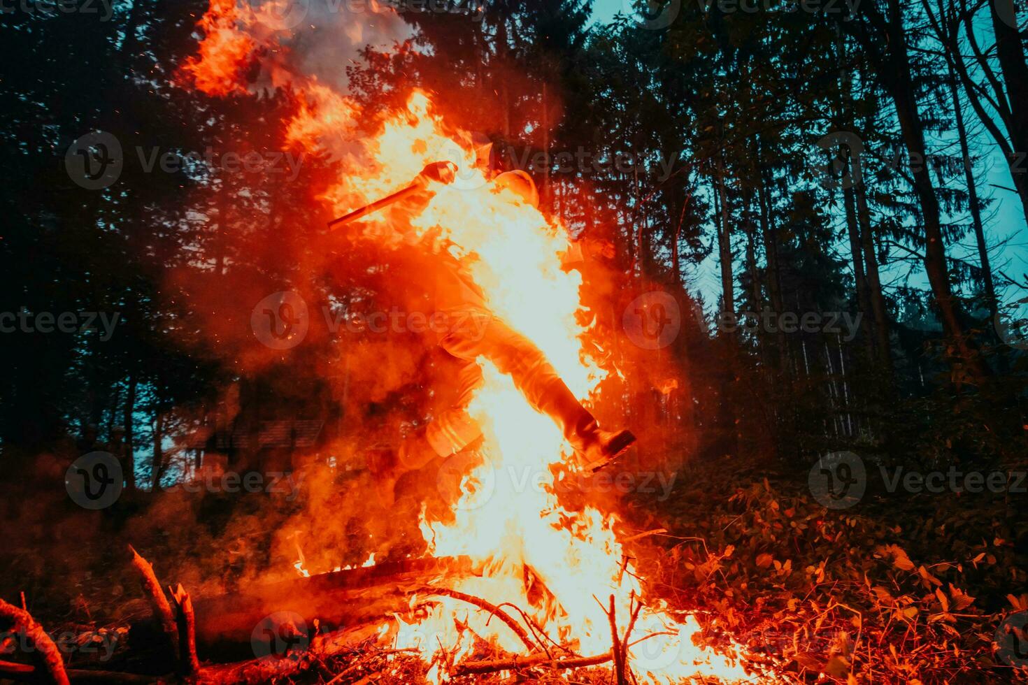Soldier in Action at Night in the Forest Area. Night Time Military Mission jumping over fire photo