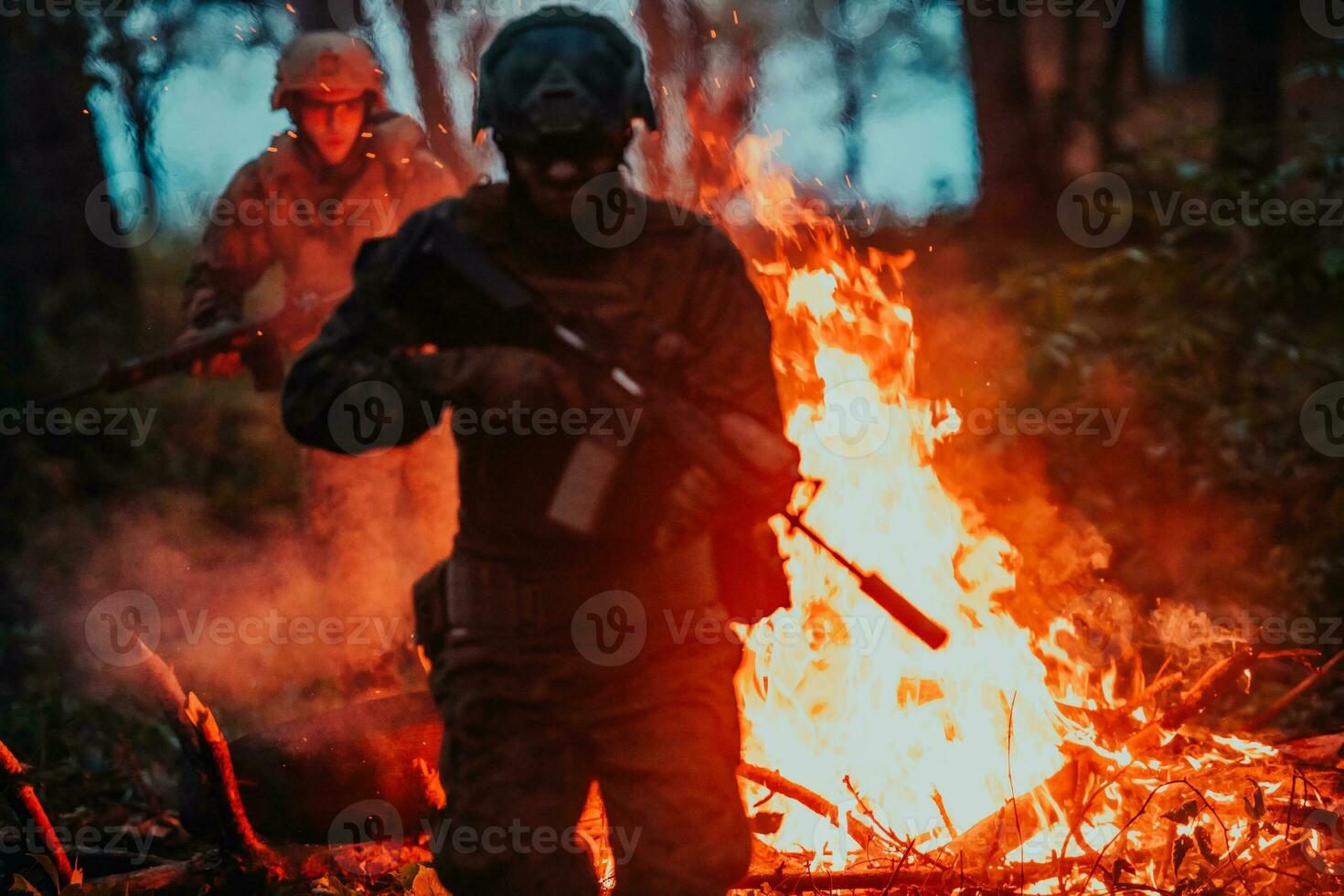 Soldier in Action at Night in the Forest Area. Night Time Military Mission jumping over fire photo
