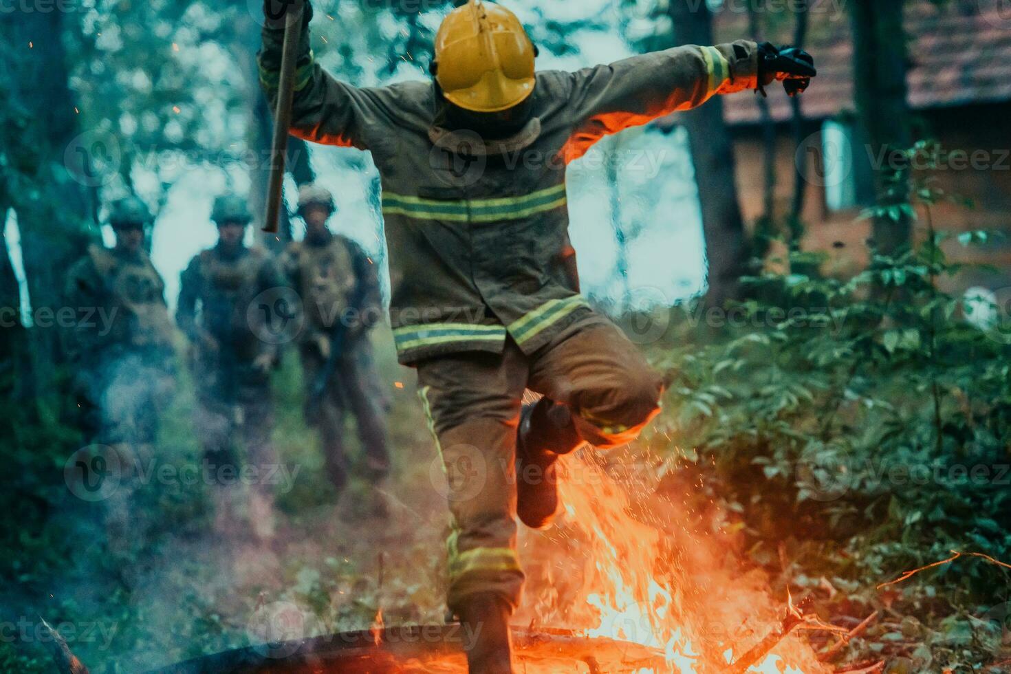 firefighter hero in action danger jumping over fire flame to rescue and save photo