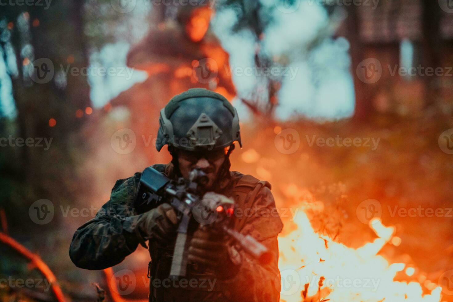 A soldier fights in a warforest area surrounded by fire photo