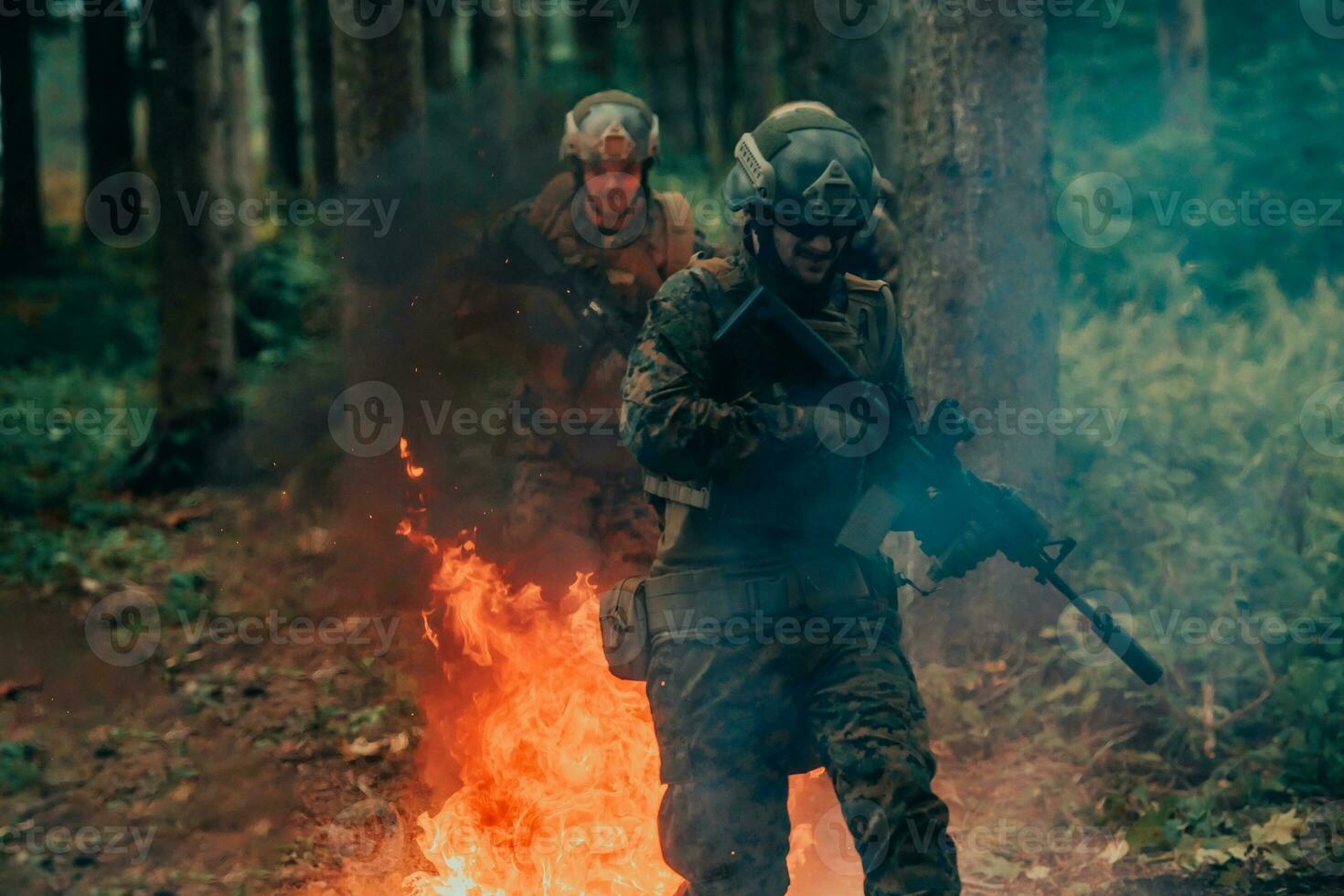 Soldier in Action at Night in the Forest Area. Night Time Military Mission jumping over fire photo