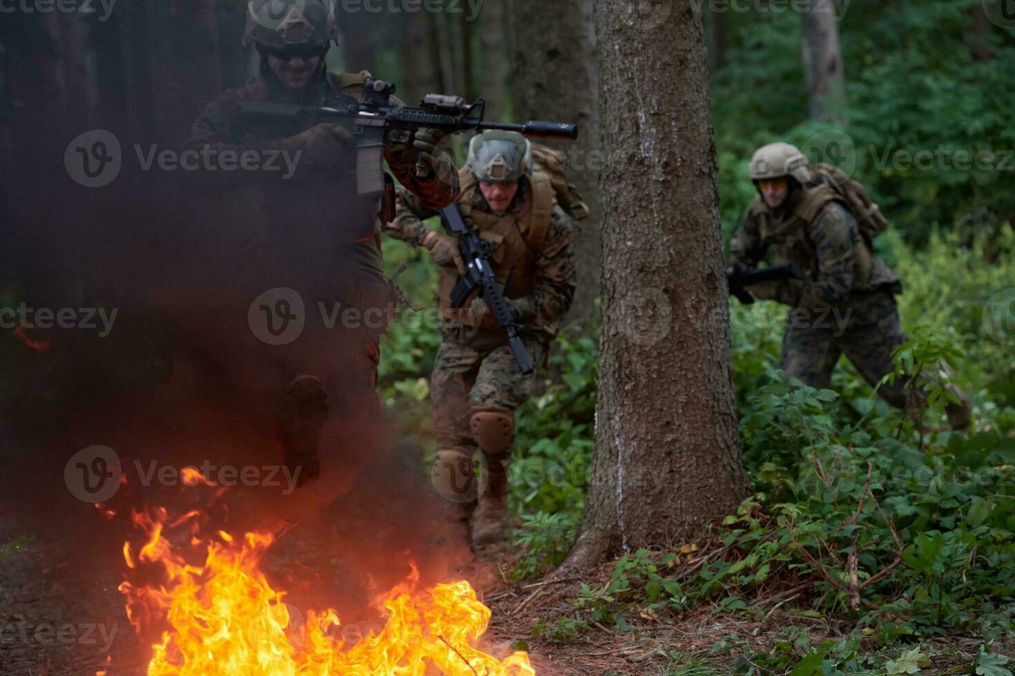 Soldier in Action at Night jumping over fire photo