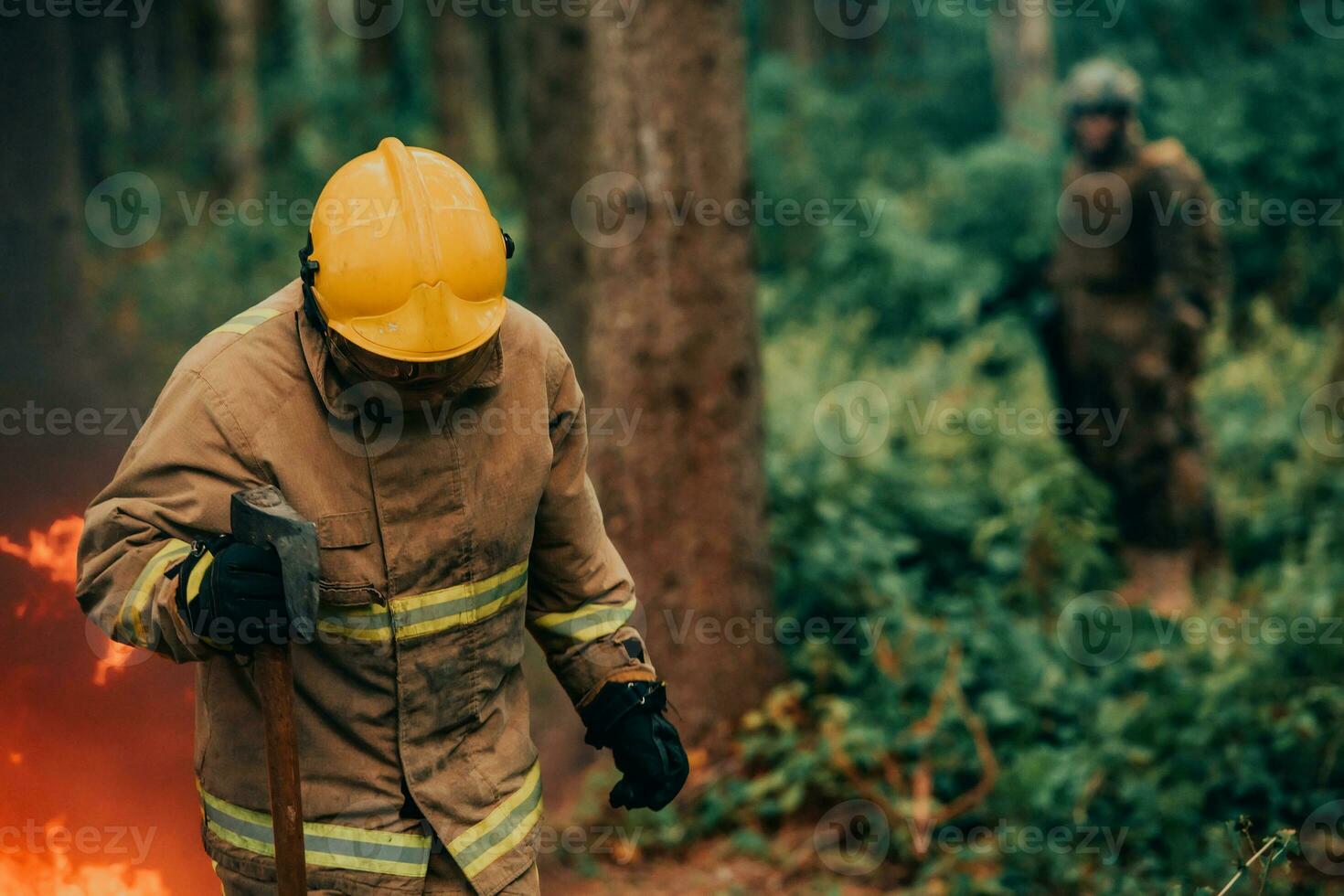 Firefighter at job. Firefighter in dangerous forest areas surrounded by strong fire. Concept of the work of the fire service photo