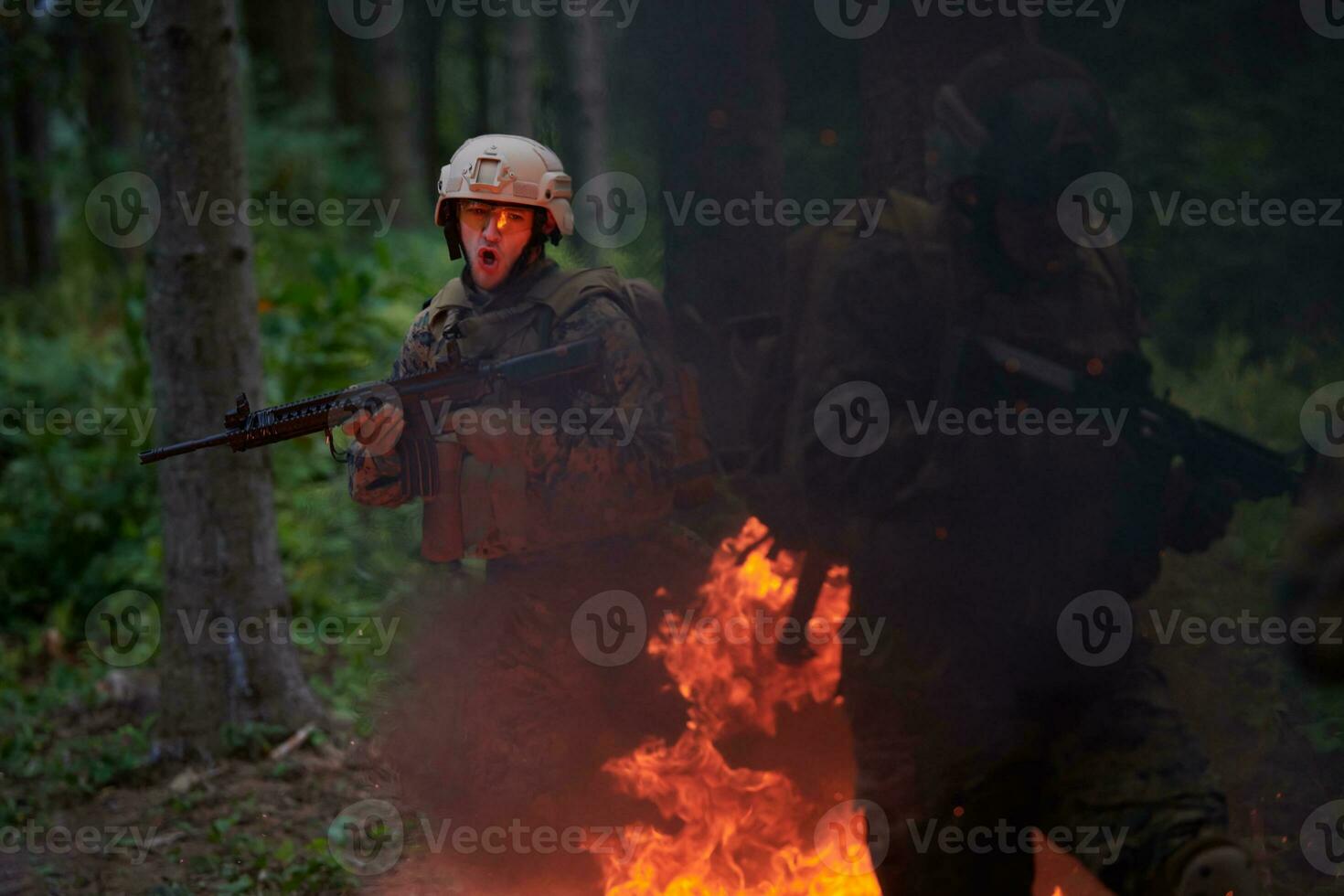 Soldier in Action at Night jumping over fire photo