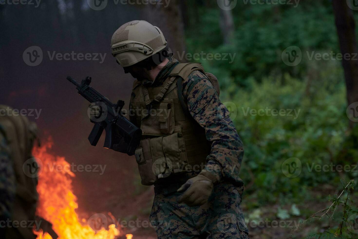 soldado en acción por la noche saltando sobre el fuego foto