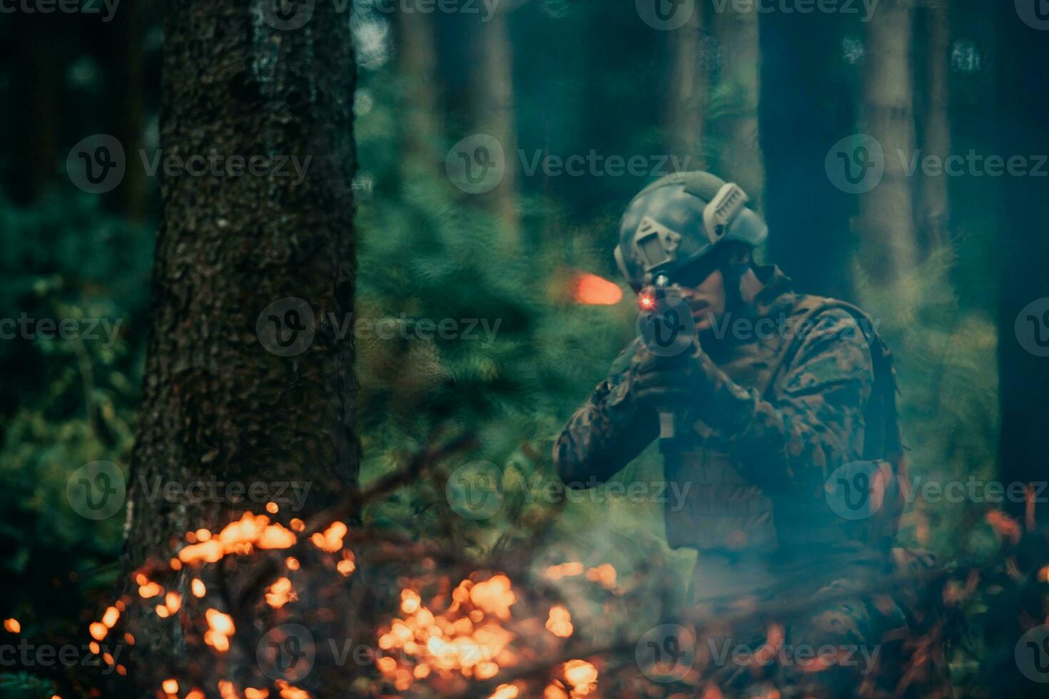A soldier fights in a warforest area surrounded by fire photo