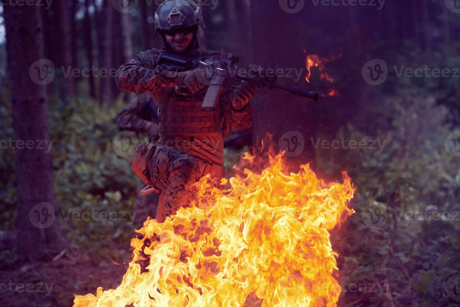 Soldier in Action at Night jumping over fire photo