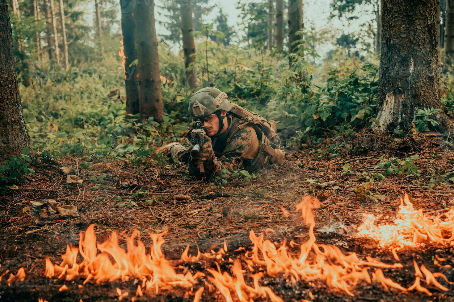 Modern warfare soldier surrounded by fire, fight in dense and dangerous forest areas photo