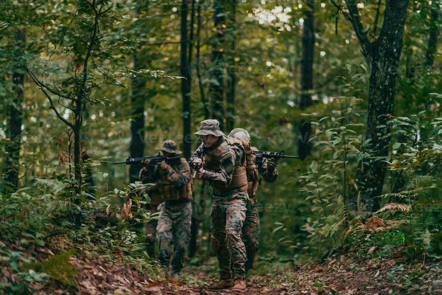 A group of modern warfare soldiers is fighting a war in dangerous remote forest areas. A group of soldiers is fighting on the enemy line with modern weapons. The concept of warfare and military conflicts photo