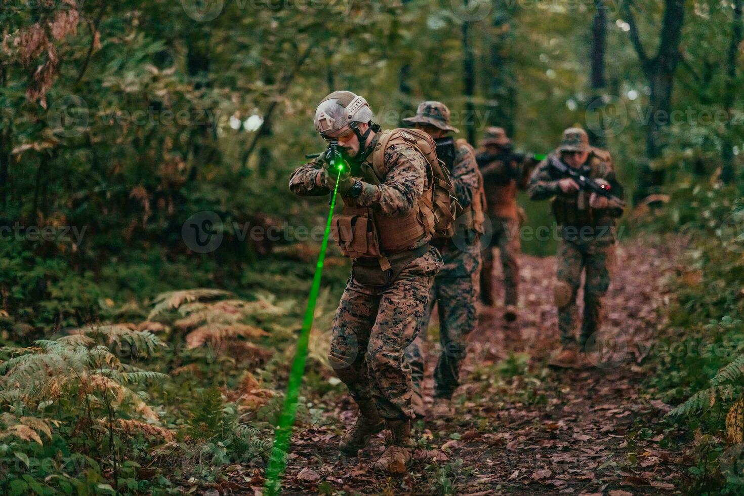 A group of modern warfare soldiers is fighting a war in dangerous remote forest areas. A group of soldiers is fighting on the enemy line with modern weapons. The concept of warfare and military conflicts photo
