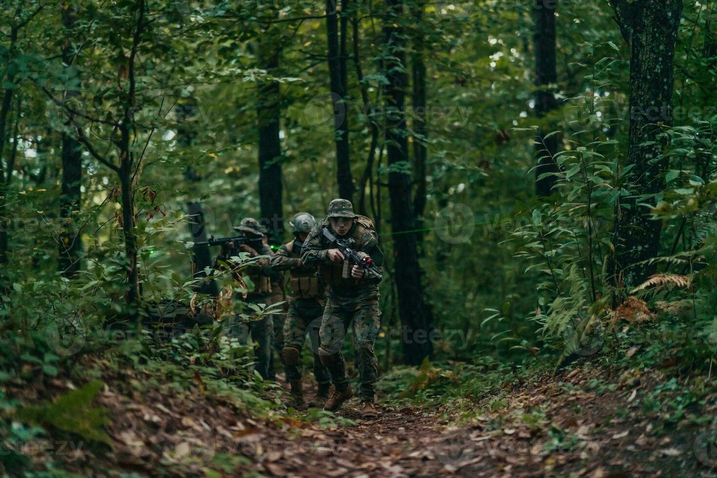 A group of modern warfare soldiers is fighting a war in dangerous remote forest areas. A group of soldiers is fighting on the enemy line with modern weapons. The concept of warfare and military conflicts photo