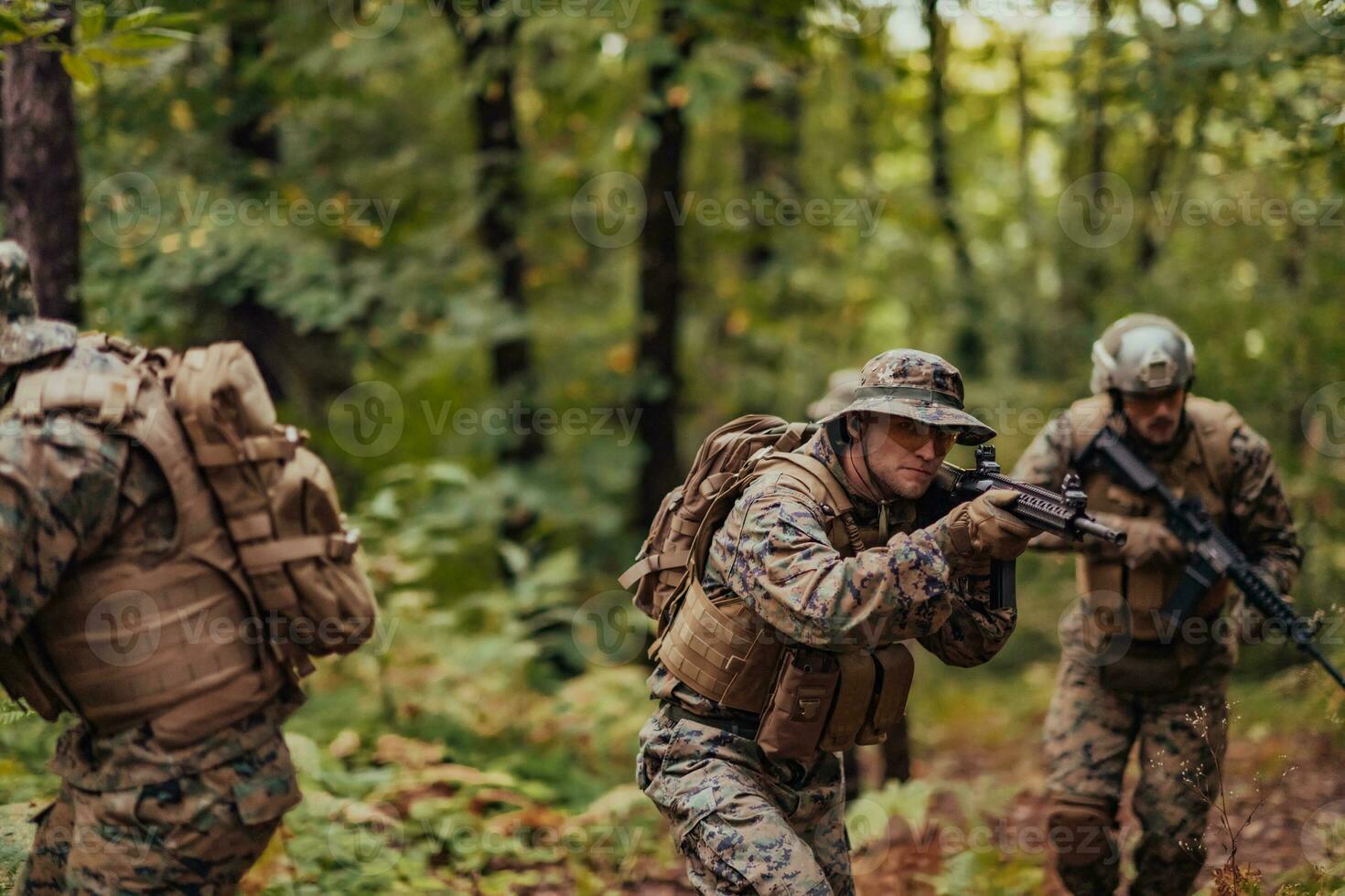 A group of modern warfare soldiers is fighting a war in dangerous remote forest areas. A group of soldiers is fighting on the enemy line with modern weapons. The concept of warfare and military conflicts photo