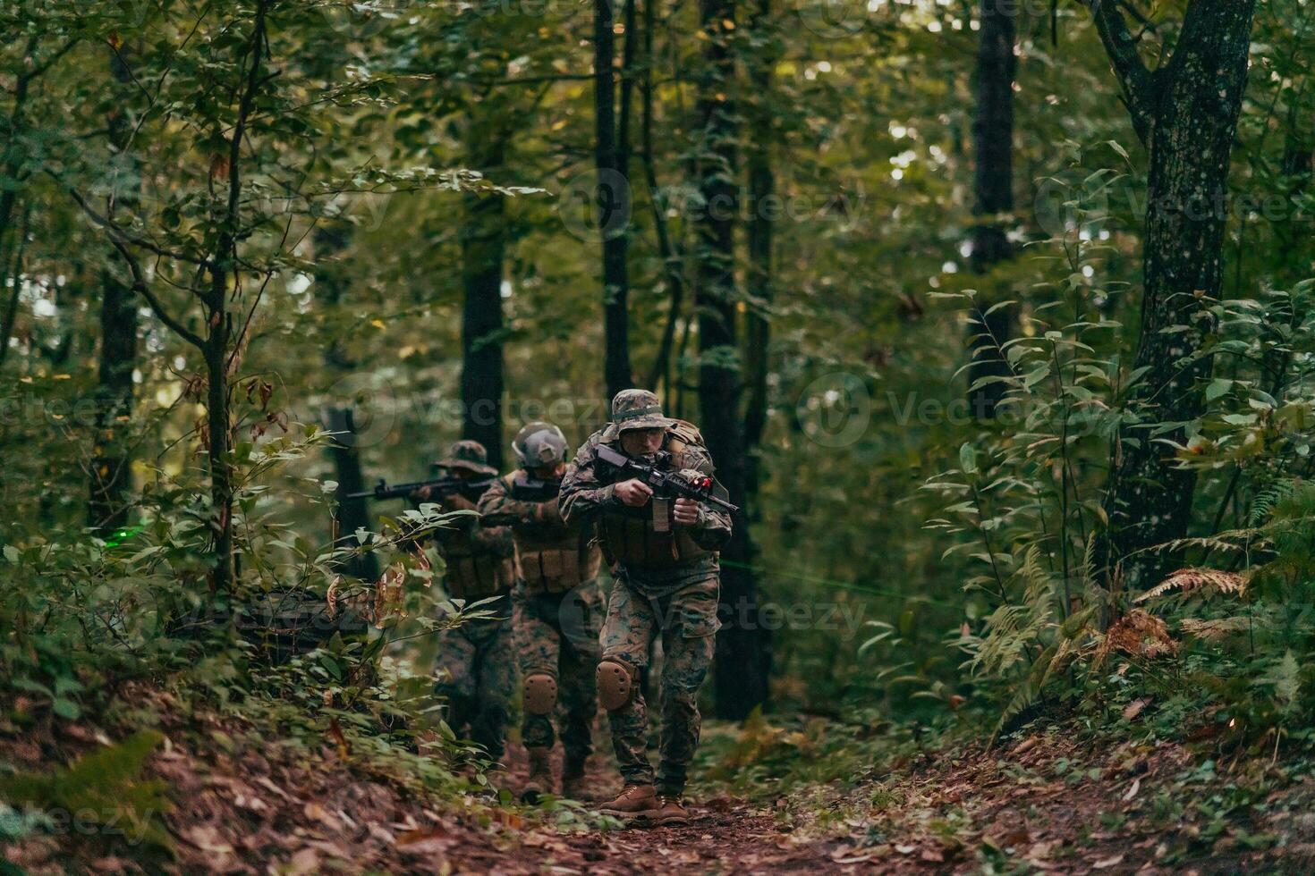 A group of modern warfare soldiers is fighting a war in dangerous remote forest areas. A group of soldiers is fighting on the enemy line with modern weapons. The concept of warfare and military conflicts photo