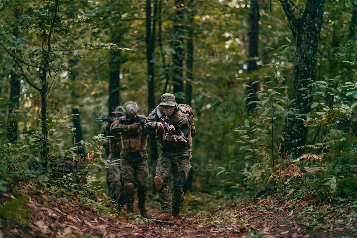 A group of modern warfare soldiers is fighting a war in dangerous remote forest areas. A group of soldiers is fighting on the enemy line with modern weapons. The concept of warfare and military conflicts photo