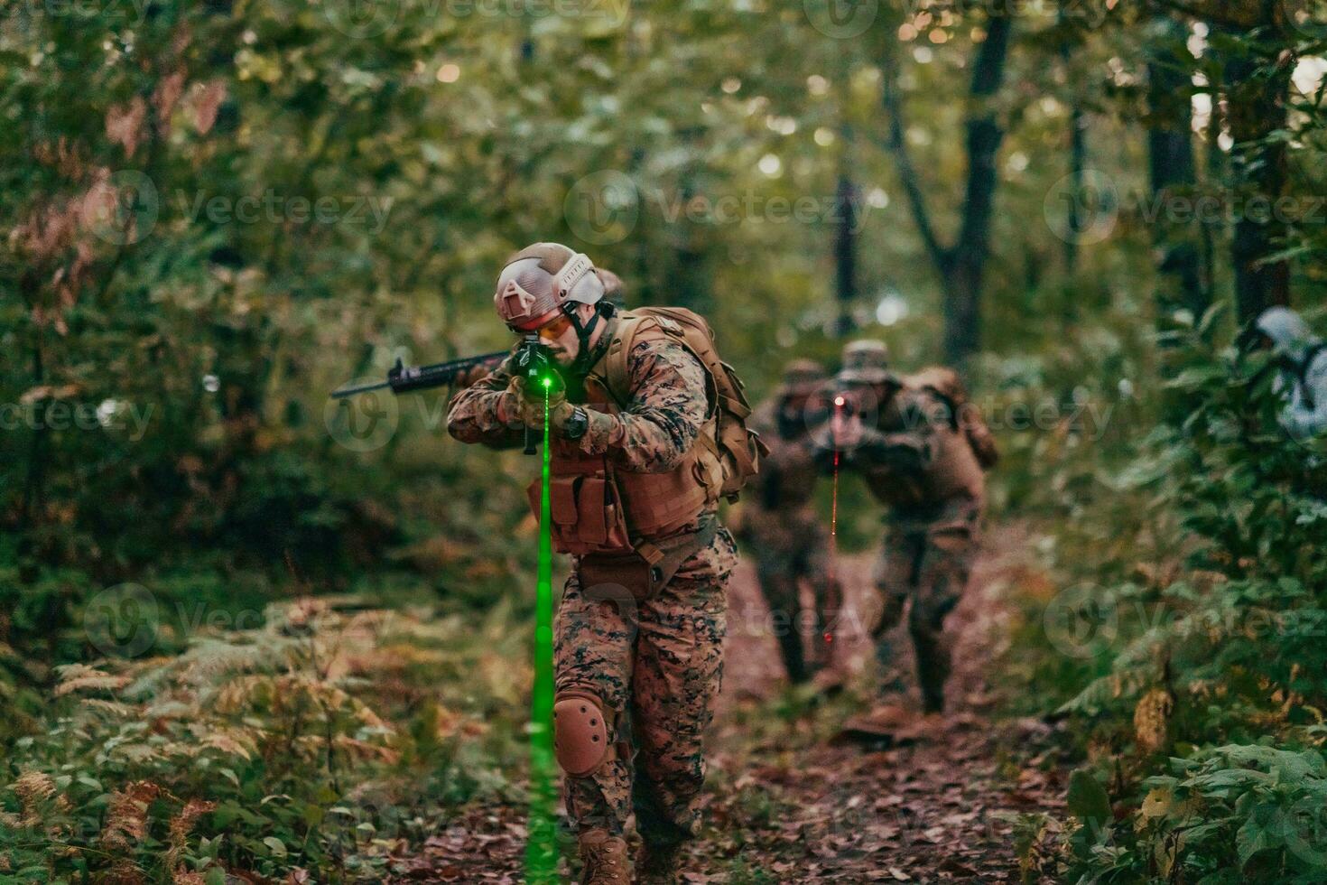 A group of modern warfare soldiers is fighting a war in dangerous remote forest areas. A group of soldiers is fighting on the enemy line with modern weapons. The concept of warfare and military conflicts photo