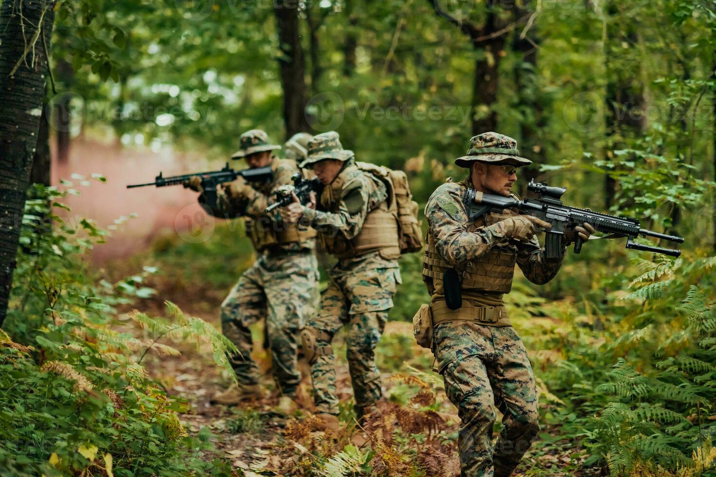 A group of modern warfare soldiers is fighting a war in dangerous remote forest areas. A group of soldiers is fighting on the enemy line with modern weapons. The concept of warfare and military conflicts photo