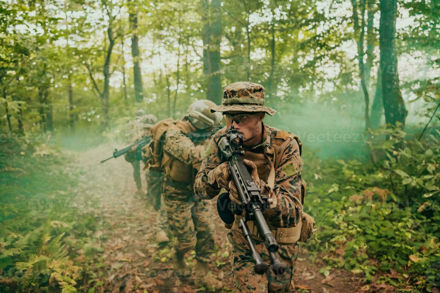 A group of modern warfare soldiers is fighting a war in dangerous remote forest areas. A group of soldiers is fighting on the enemy line with modern weapons. The concept of warfare and military conflicts photo